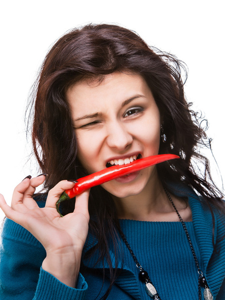 woman holding red hot chili pepper in mouth - Foto, Imagen