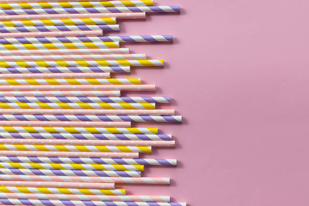 різнокольорові паперові соломинки на рожевому тлі для вечірки. Анотація барвисті паперові соломинки, які використовуються для пиття води або безалкогольних напоїв. Копіювати простір
 - Фото, зображення