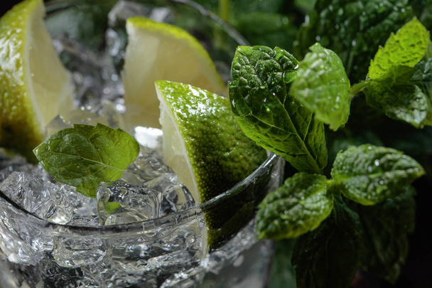 Cocktail mojito au citron vert, glace et menthe sur fond sombre. Concentration sélective
 . - Photo, image