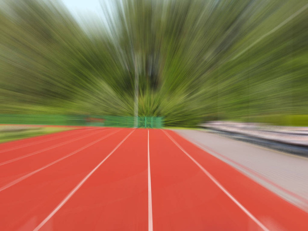 Red treadmill at the stadium. Element of a sports complex. Outdoor coating for sports. A place for competitions in athletics. lubrication - geometric perspective of the speed of movement towards  - Photo, Image