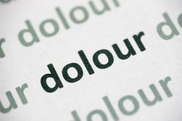 palabra dolour impreso en papel blanco macro
 - Foto, Imagen