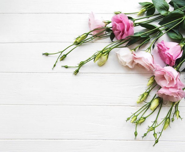 Φρέσκο eustoma ροζ λουλούδια πλαίσιο σε φόντο ξύλινη - Φωτογραφία, εικόνα