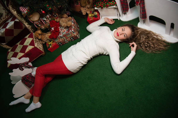 girls lie next to the Christmas tree with gifts - Zdjęcie, obraz