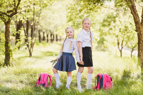 金髪のかわいい女の子の学校の制服、白の靴下とバックパック soutdoors - 写真・画像