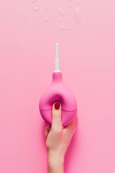 cropped shot of woman holding douche on pink - Фото, изображение