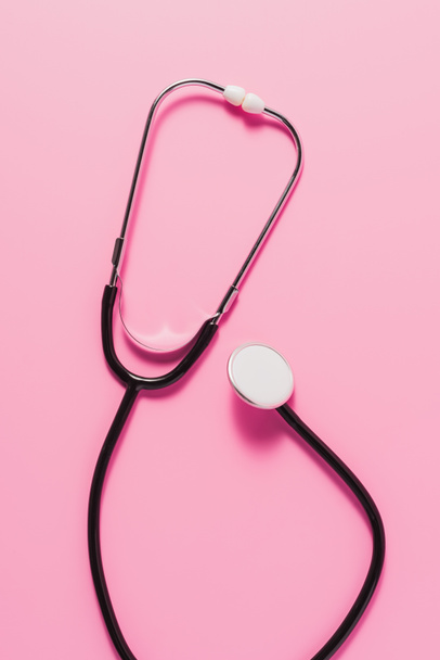 Ansicht des Stethoskops von oben auf rosa Oberfläche - Foto, Bild