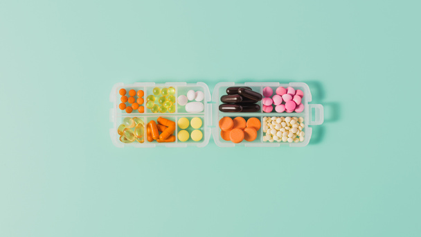 vista superior de la caja de plástico con varias píldoras ordenadas en azul
 - Foto, Imagen