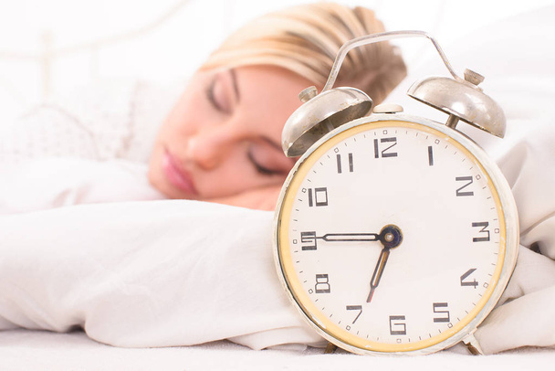 soon to wake up for sleeping attractive young woman with alarm clock - Photo, Image