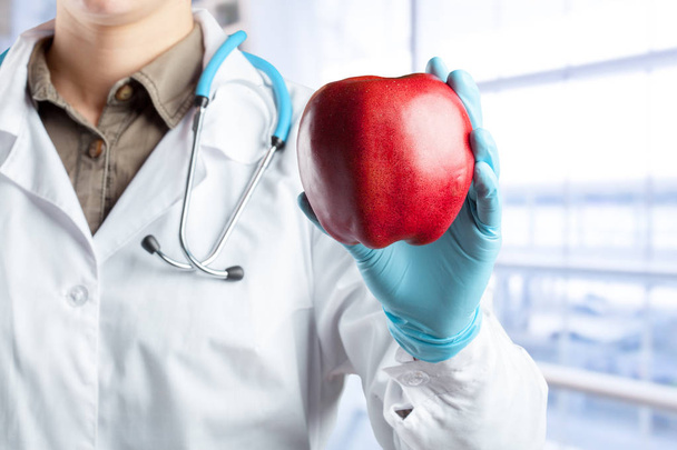 dentist holding a ripe apple - Foto, Imagen