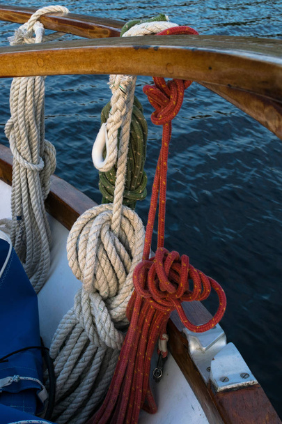 Mavi Akdeniz 'de tahta yelkenli. Güverte zemininde halatlar, düğümler ve tahtalar olan klasik bir yelkenli yatının detayları.. - Fotoğraf, Görsel