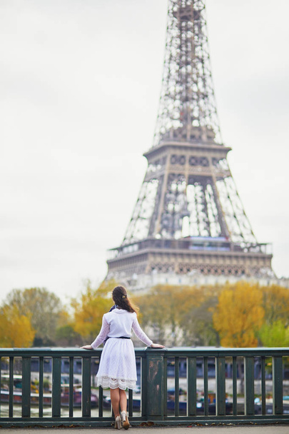 Happy young woman in white dress near the Eiffel tower in Paris, France - Fotoğraf, Görsel