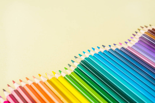 Art concept - Top view of color pencil wave on yellow paper background for mockup design - Foto, afbeelding