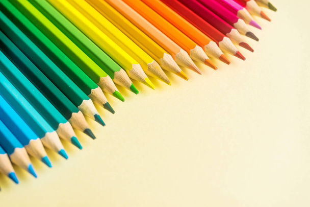 Art concept - Top view of color pencil wave on yellow paper background for mockup design - Foto, Imagem