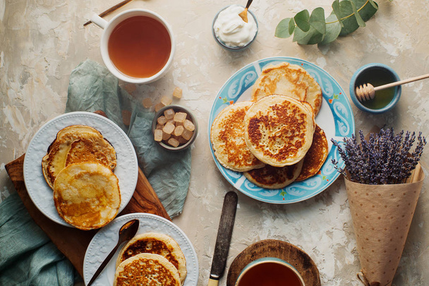 tea, pancakes, honey, cream sauce and lavender on concrete table - Φωτογραφία, εικόνα
