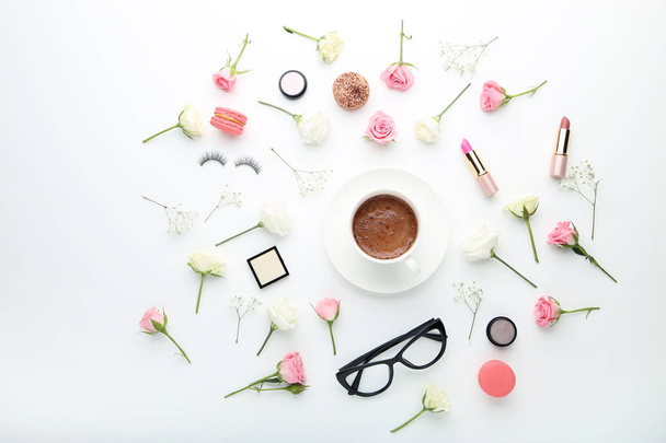 Flowers with cup of coffee and makeup cosmetics on white background - Photo, Image