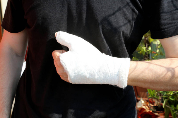 törött ember kezét a kórházban, a fekete póló háttér ortopéd gipsz - Fotó, kép