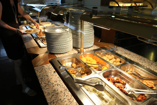 ресторан самообслуживания с большим количеством блюд и лотков, полных продуктов питания для клиентов
 - Фото, изображение