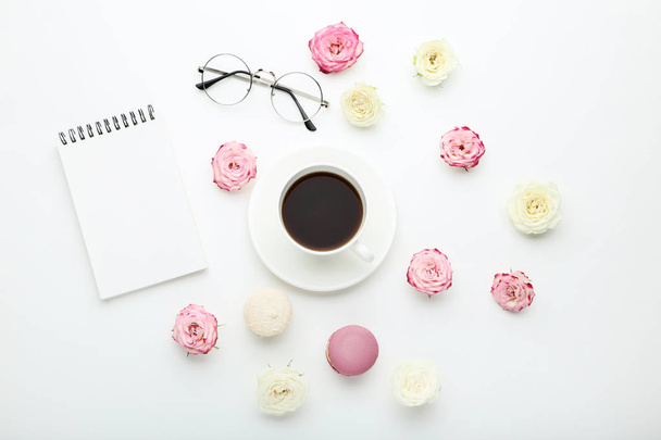 Rose flowers with cup of coffee and macaroons on white background - Фото, изображение