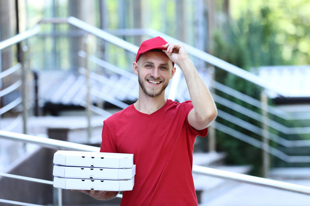 Delivery man holding cardboard boxes with pizza  - Foto, immagini