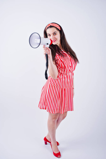 Portrait of a young beautiful woman in red dress talking into megaphone. - Foto, Bild