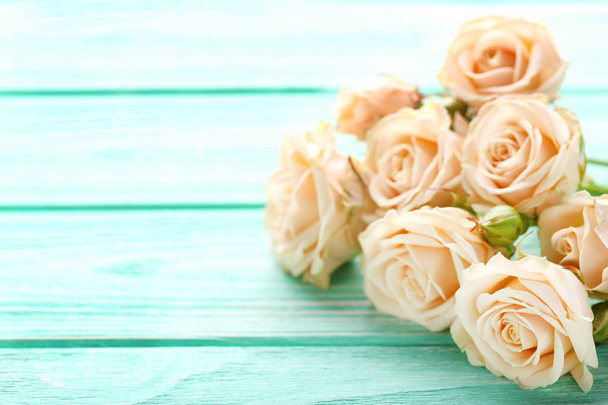 Bouquet of beige roses on mint wooden table - Фото, зображення