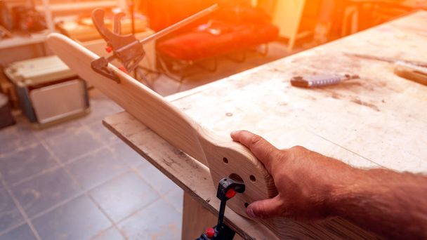 Zblízka mladík tvůrce tesařské práce s dřevěnou deskou v dílně - Fotografie, Obrázek