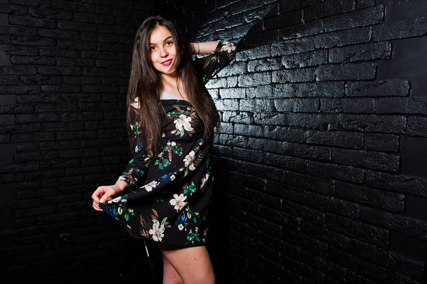 Portrait of a fabulous young woman in floral dress in the dark studio. - Foto, afbeelding