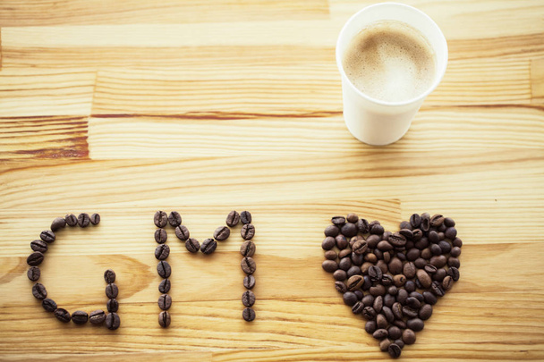 Guten Morgen. Coffee to go. Kaffeetassen mit Deckel und Kaffeebohnen auf Holztischboden. - Foto, Bild