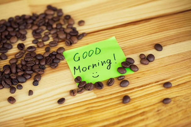 おはようございます。移動するコーヒー。木製のテーブルの Backound のコーヒー豆. - 写真・画像