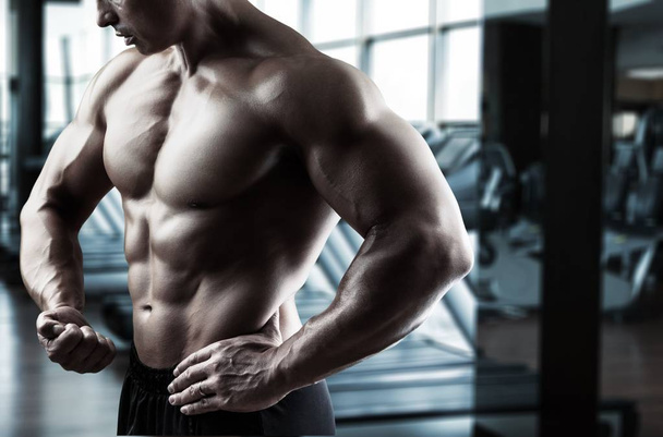 Muscular young man in gym - Foto, Imagen