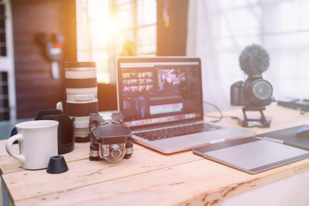 Το γραφείο σπίτι του Vlogger ή δημιουργική παραγωγός freelance στην επιφάνεια εργασίας με φακό κηφήνας Laptop και φωτογραφική μηχανή στο τραπέζι. - Φωτογραφία, εικόνα