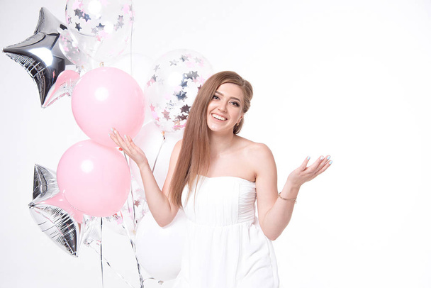 mulher sedutora feliz em vestido de verão branco se divertindo com balões isolados no fundo branco
 - Foto, Imagem