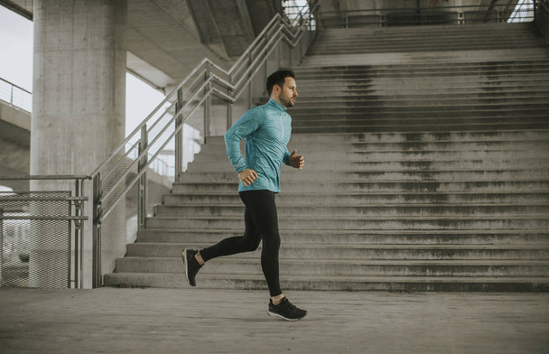Young man running fast outdoors in the city - Valokuva, kuva