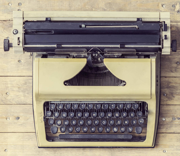 Old Russian typewriter over retro wooden background. Vintage equipment. - Фото, зображення