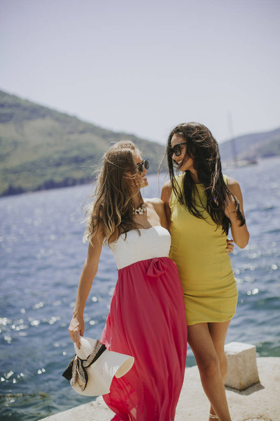 Twee mooie jonge vrouwen die plezier aan zee op een zomerdag - Foto, afbeelding
