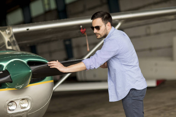 Handsome young pilot checking ultralight airplane before flight - Photo, Image