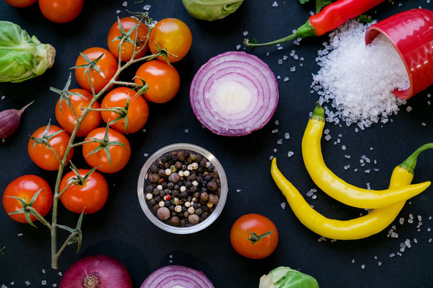 Close up van kleurrijke specerijen en verse groenten voor het koken op donkere metalen achtergrond met ruimte voor tekst. Bovenaanzicht. Bio gezonde voedingsmiddelen en nieuwe voedselingrediënten. - Foto, afbeelding