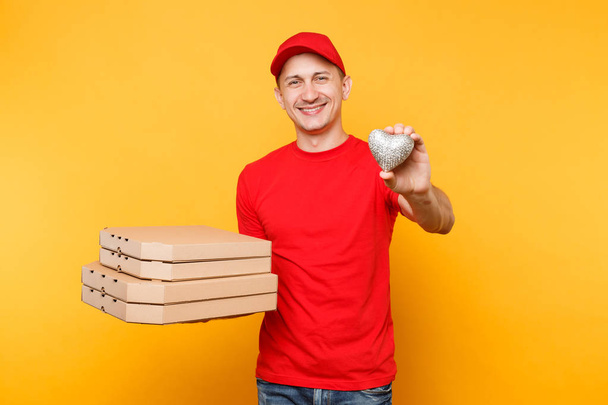 配達人はキャップ t シャツ黄色の背景に分離されて与える食品注文のピザ箱です。段ボール flatbox の中心のイタリアのピザを保持している制服を着た男性従業員 pizzaman 宅配便。サービスのコンセプト - 写真・画像
