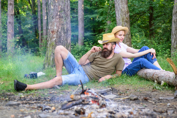 Family activity for summer vacation in forest and nature. Couple relaxing after gathering mushrooms in wild for food. Family traditions. Family relaxing near bonfire after day of mushroom hunting - Valokuva, kuva