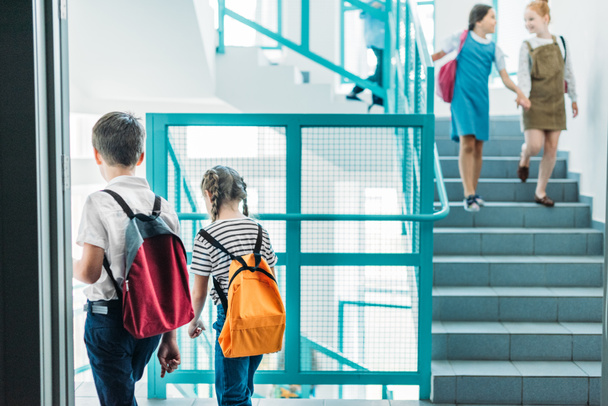 elementary age classmates walking down stairs at school - Φωτογραφία, εικόνα