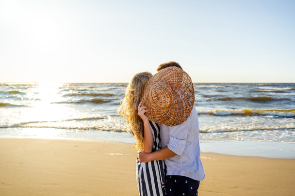 Μερική άποψη του το ζευγάρι στην αγάπη κρύβονται πίσω από το ψάθινο καπέλο στην παραλία στη Ρίγα της Λετονίας - Φωτογραφία, εικόνα