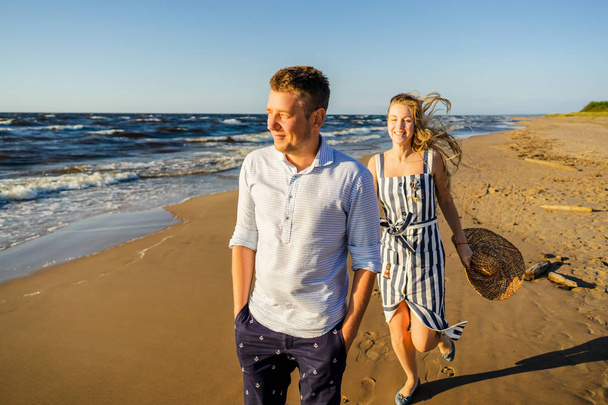 Riga, ラトビアの砂浜の上を歩いての愛に幸せなカップルの肖像画 - 写真・画像