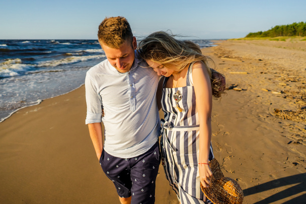 portrait of young couple in love walking on sandy beach in Riga, Latvia - Photo, Image