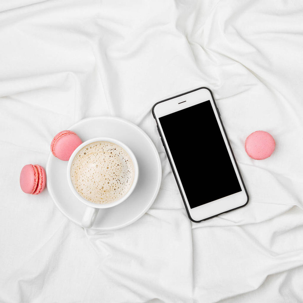 top view of cup of coffee and Smartphone  on bed. - 写真・画像