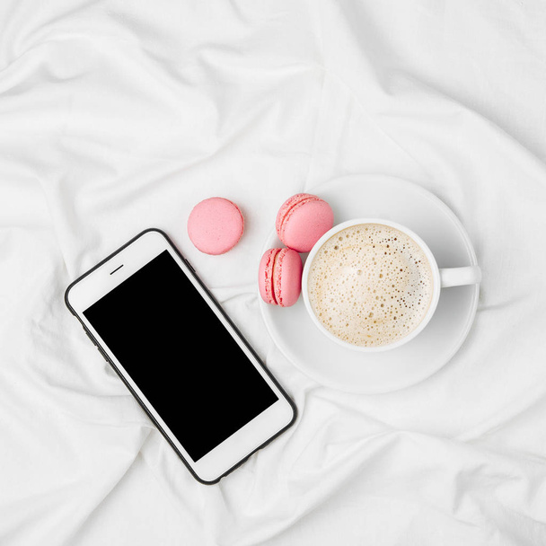 Cup of coffee and Smartphone  on bed. - Foto, Imagem