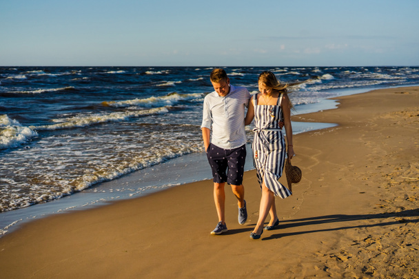 pareja joven enamorada abrazando y caminando en la playa de arena en Riga, Letonia
 - Foto, imagen