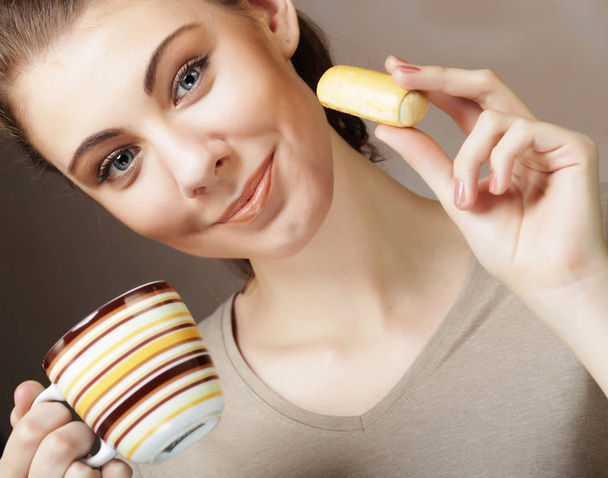 lifestyle, people and food concept: young woman with coffee and cookies - Foto, afbeelding