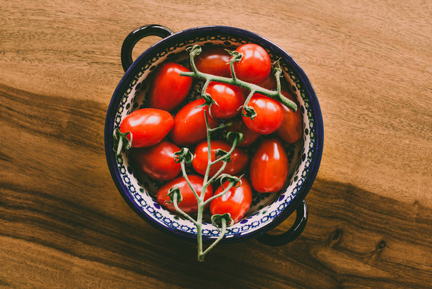 Крупним планом здорові яскраві блискучі червоні помідори як харчова фотографія на фоні дерев'яного столу
 - Фото, зображення