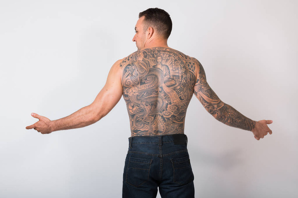 Портрет человека без рубашки с татуировками на белом фоне
 - Фото, изображение
