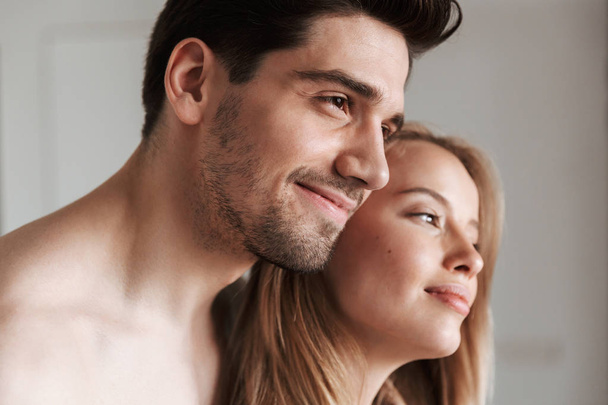 Photo of young cute pleased happy loving couple in home indoors hugging. - Photo, Image